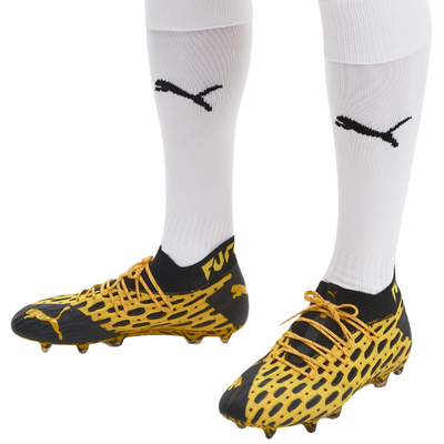 Puma Future 5.1 Netfit Firm Ground Soccer Cleats Junior Yellow/Black lower legs of person wearing these shoes